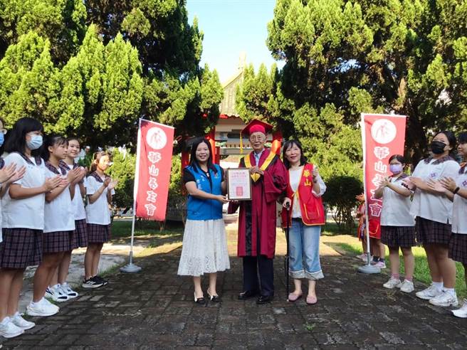 陳孝祿穿上博士服接受校長方麗萍頒發贈書表揚。（李京昇攝）
