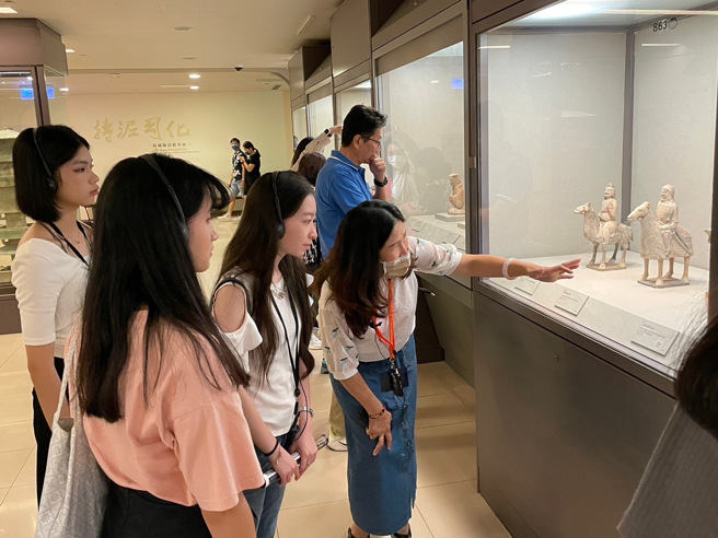 越南新住民导览员黄嘉慧正在介绍北齐加彩陶武士俑　（左起为新二代亲善大使陈虹洁、赖佳怡及李盈璇）。移民署提供
