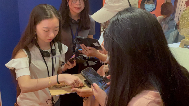 图说3.新二代亲善大使团一同体验故宫解谜游戏（左一为新二代亲善大使李盈璇）。（移民署提供）