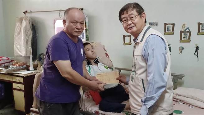 麻豆区长柳世雄（右）探视身障生陈冠廷（中），并致赠助学金给陈父（左）。（麻豆区公所提供／张毓翎台南传真）