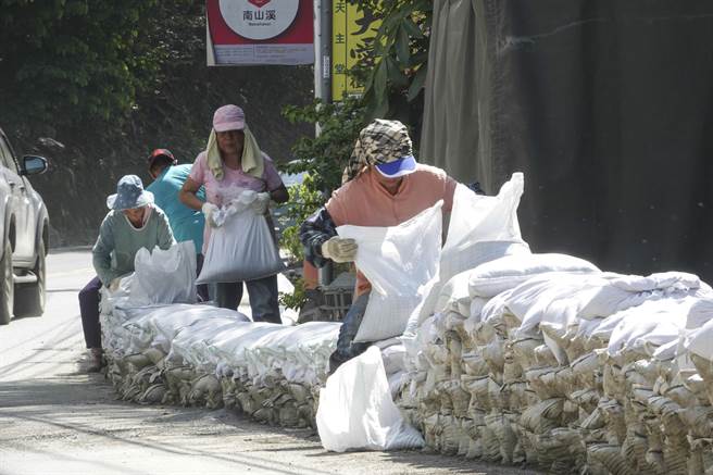 中颱「苏拉」逼近台湾，气象局29日下午发布陆上警报，上次「卡努」颱风受到重创的南投仁爱乡台14线一带居民，目前仍在重建满目疮痍的家园，面对「苏拉」新颱威胁，南丰村民在自家门前堆放砂包筑起长堤，预防可能再次来袭的大雨及土石流。（黄子明摄）