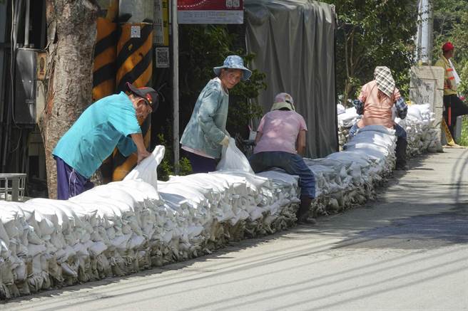中颱「苏拉」逼近台湾，气象局29日下午发布陆上警报，上次「卡努」颱风受到重创的南投仁爱乡台14线一带居民，目前仍在重建满目疮痍的家园，面对「苏拉」新颱威胁，南丰村民在自家门前堆放砂包筑起长堤，预防可能再次来袭的大雨及土石流。（黄子明摄）