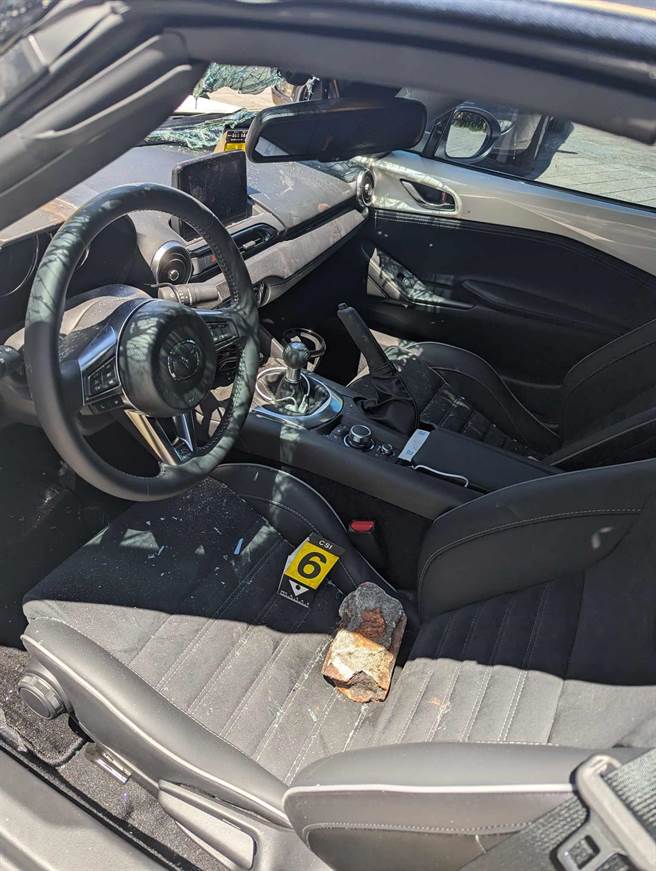 「开锁达人」涂志浩日系跑车挡风玻璃遭砸，沾血的砖头还留在他的车内。（永和警分局提供）
