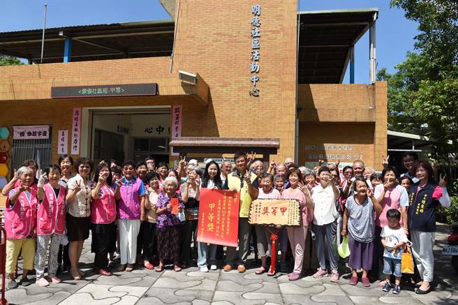 陳美琦代表縣長鍾東錦貼榜贈匾向明德社區致賀。（苗栗縣政府提供／李京昇苗栗傳真）