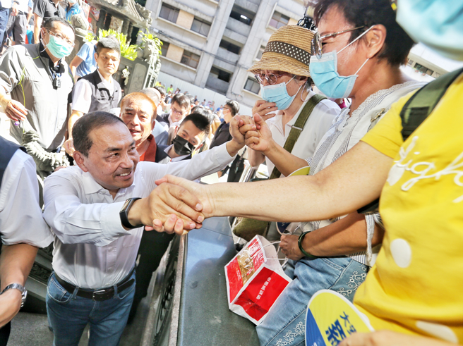 国民党总统参选人侯友宜（左）29日到台北火圣庙参拜并与大安区里长茶叙座谈，受到现场民眾热情欢迎。（资料照,杜宜谙摄）