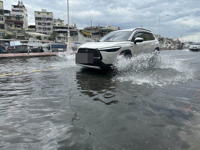 受年度大潮影响，高雄市鼓山区哨船街道路积水，骑士冒险涉水前行。（杨舒婷摄）