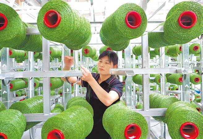 图为工人在人造草坪智慧化厂房作业。（图／新华社）