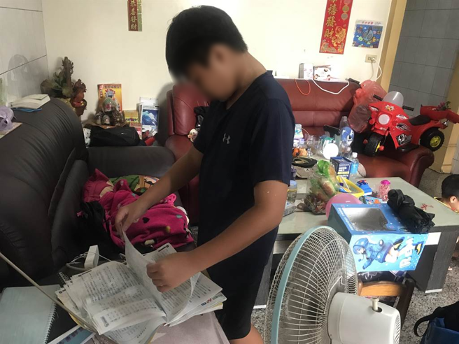 有小朋友昨天开学才刚拿到的新课本连同书包一起遭水淹，只好请假留在家里帮忙整理，并无奈地用电风扇把溼透的书本吹乾。（谢佳潾摄）