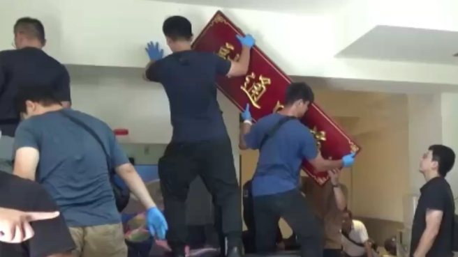 警武裝破門見「關公像」， 當場即強拆堂口匾額，警所查扣「融通四海」匾額，暗喻是四海幫堂口。（照片 / 劉詠韻翻攝）
