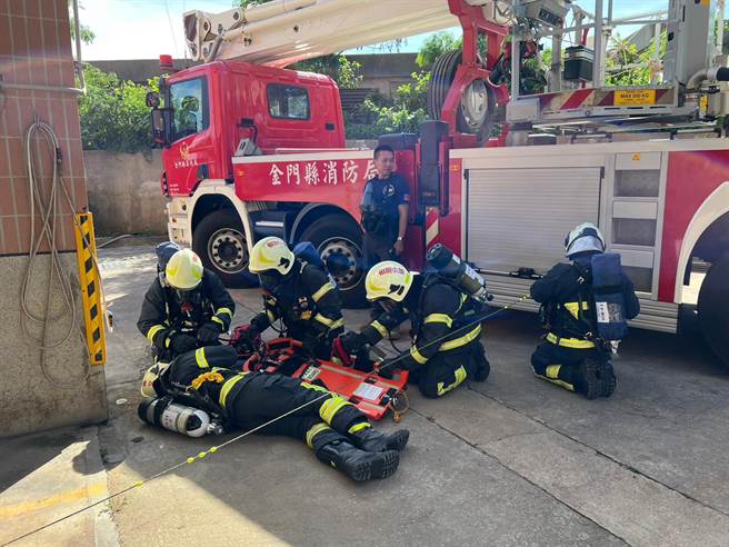 抢救人员于找寻受困者后，运用快速救援板（FAST BOARD）将受困消防员固定于快速救援板上。(图／金门消防局提供)