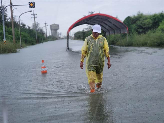 口湖鄉長李龍飛腳下是福安橋位置，擋水板擋起來的海水深度最高達45公分。（周麗蘭攝）
