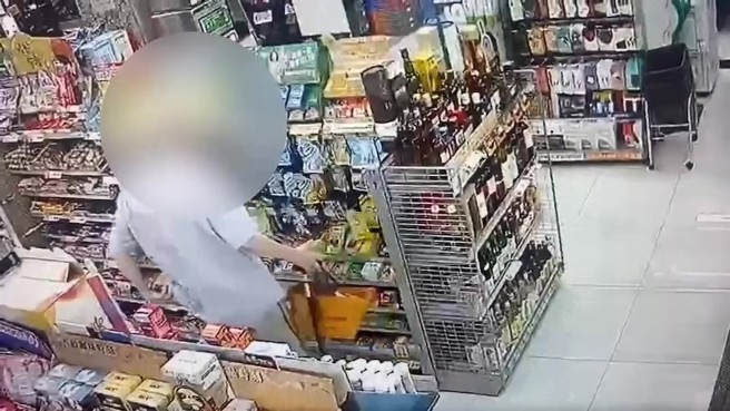 台北市1名80歲李姓老翁日前於中正紀念堂附近連鎖超商，趁店員不注意拿走一瓶威士忌放入褲子後口袋。（翻攝畫面）