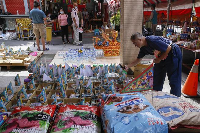 一名男子找到去世爱犬供品后拍照留念。（黄子明摄）