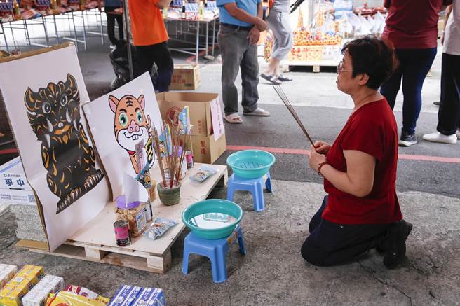 参加动物灵普渡的民眾跪在庙埕祭拜虎爷分身。（黄子明摄）