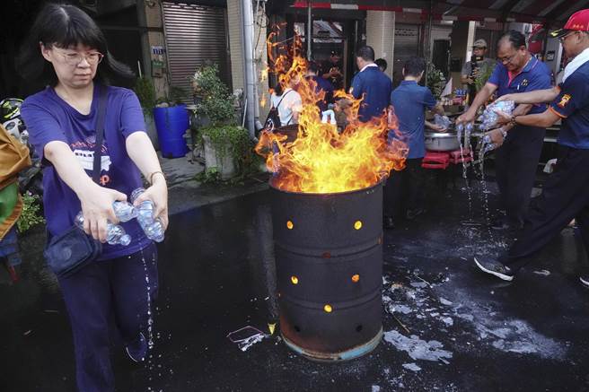 诵经结束后，志工拿着开路水沿路泼洒引领动物灵。（黄子明摄）