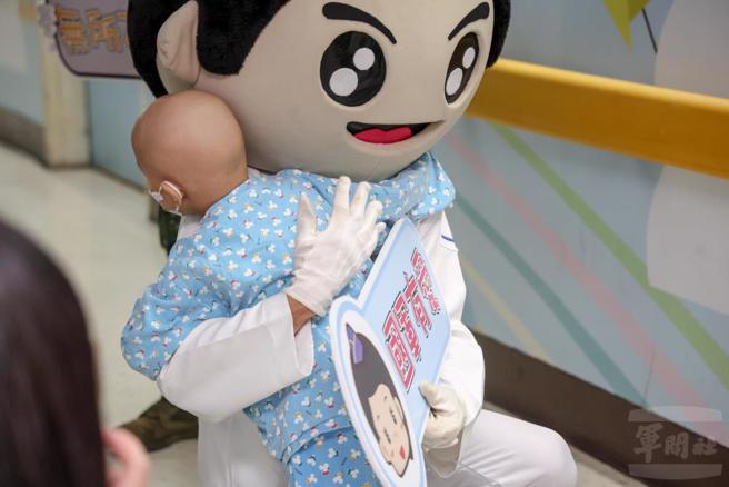 活动结束后，小朋友依依不舍与偶头娃娃拥抱道别。（军闻社提供）