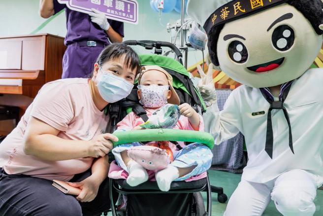 病童及家属开心与偶头娃娃合影。（军闻社提供）