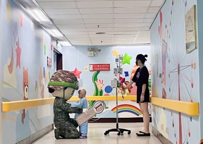 小病童紧牵着军方的陆军气偶娃娃的手直到结束都不愿意放开，让现场家属、官兵及医护人员看得都红了眼眶，感动鼻酸。(军闻社提供)