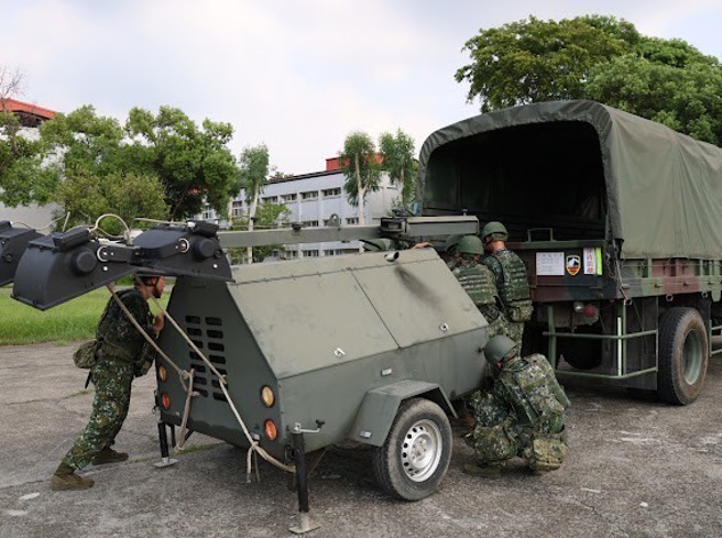 52工兵群官兵合力将发电机及救灾器具搬运上车，待命执行灾防任务。(陆军十军团提供)