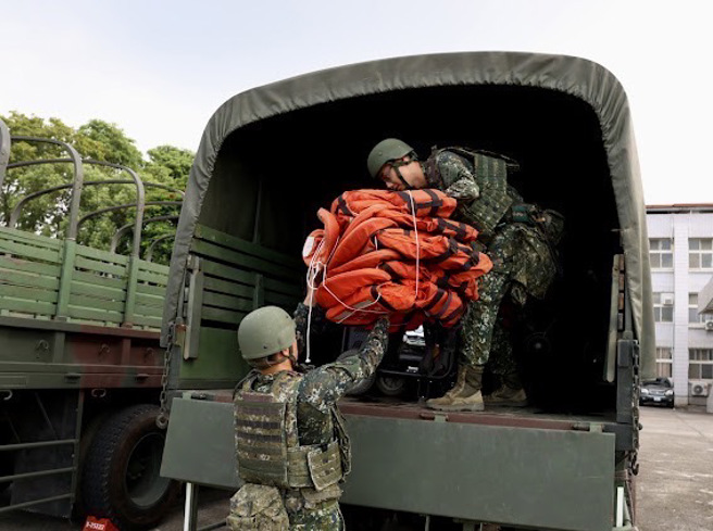 52工兵群官兵合力将发电机及救灾器具搬运上车，待命执行灾防任务。(陆军十军团提供)