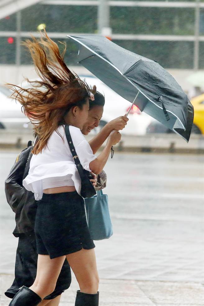 海葵颱風3日下午3時40分登陸台東東河，劃下1472天無颱風登陸句點，北部地區也帶來陣陣風雨，假日午後，不少民眾冒著風雨出門逛街，在台北車站附近瞬間陣風吹襲路上行人，許多人的傘撐不住強風，瞬間開花反折，頭髮也被風吹得七零八亂。（鄧博仁攝）