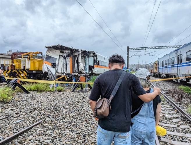 陈姓幸存者带着当天没有在车上的妻子，看着太鲁阁号的车厢残骸，百感交集。（张志康摄）