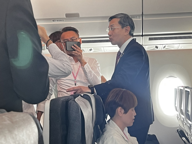 外交部次长李淳（右）在总统出访专机上和媒体团谈话。（游念育摄）