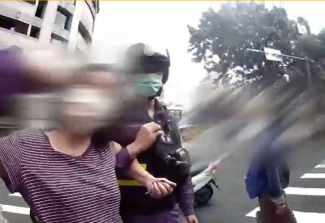 行人闯红灯遭开单，妇人辱骂警察。(翻拍影片)