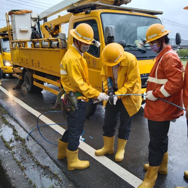 海葵颱风来袭期间，因冈山区大埔路颱风风势较强，造成低压断线，张峻玮(中)和其他同仁前往事故现场进行接线復旧工程。（图片来源：台电高雄区处提供）
