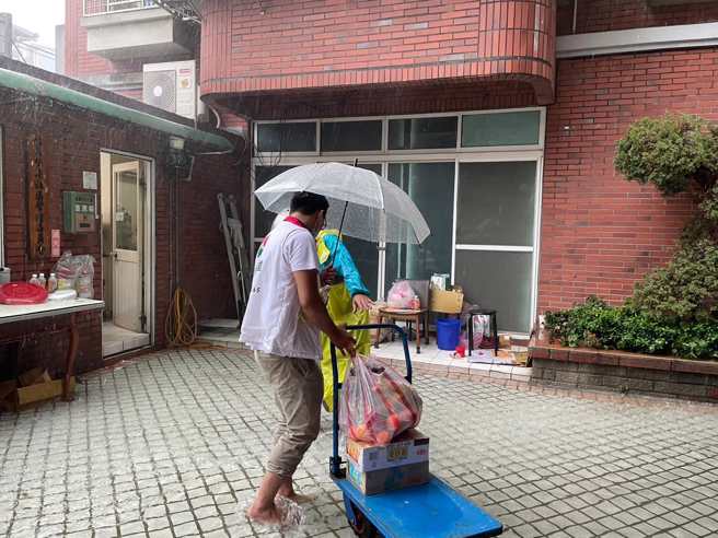 信义房屋新庄公园店在大雨中协助社区运送普渡物资。(图/信义房屋 提供)