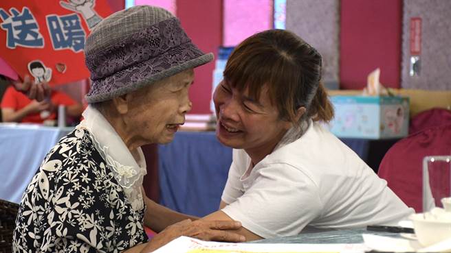 88岁的陈杨丽蓉（左）紧握每个妈妈的手，告诉她们「苦日子会过去」。（周丽兰摄）