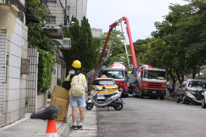 台北市大直街94巷弄內民宅因工地施工嚴重傾斜，9日有民眾全副武裝回家收拾行李。（杜宜諳攝）