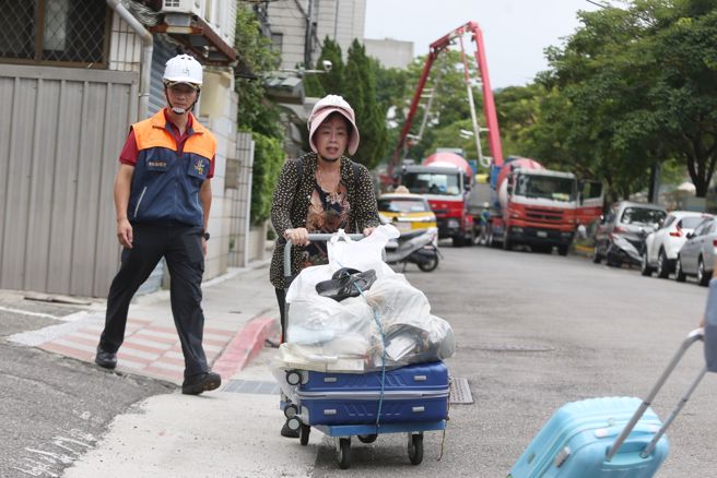 台北市大直街94巷弄内民宅因工地施工严重倾斜，有民眾9日全副武装回家收拾行李。（杜宜谙摄）