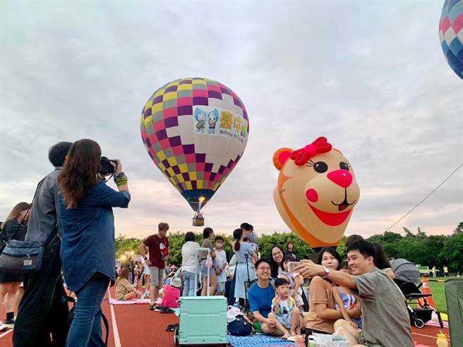 台中石冈热气球嘉年华活动9日、10日两天再度登场，上午民眾席地而坐野餐、搭乘热气球，有人按下相机快门抢拍热气球缤纷起飞升空的美景。（读者提供／张妍溱台中传真）