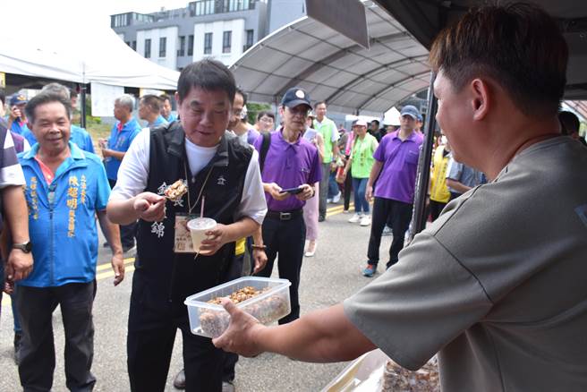 苑里镇农会9日上午举办「找稻幸福」活动，农特产品业者热情招待苗栗县长锺东锦试吃。（谢明俊摄）
