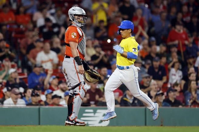 金莺捕手麦坎(左)看着红袜吉田正尚得分。（美联社）