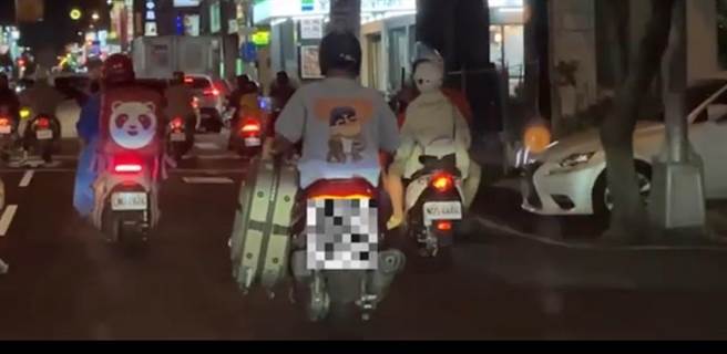 有民眾駕車行經台中市北區漢口路段，看到1名騎士左手拎著行李箱停等紅燈，綠燈亮起也一路拎著行李箱行駛。（翻攝自記者爆料網／馮惠宜台中傳真）