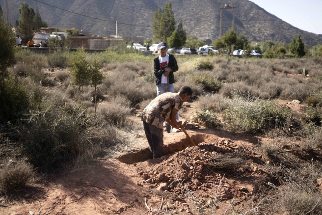  画面为山村Ouargane居民自行挖掘坟墓、下葬亲友。（图／美联社）