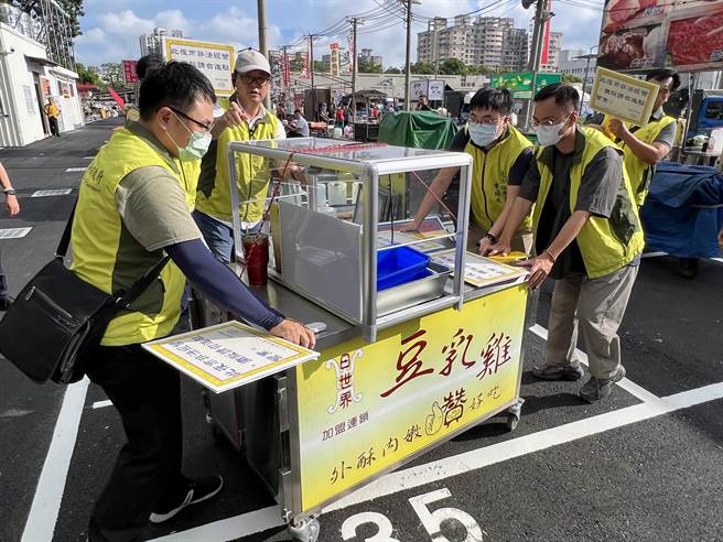 台南市市场处长陈豪吉带队搬移置放大东夜市内的摊具。（洪荣志摄）