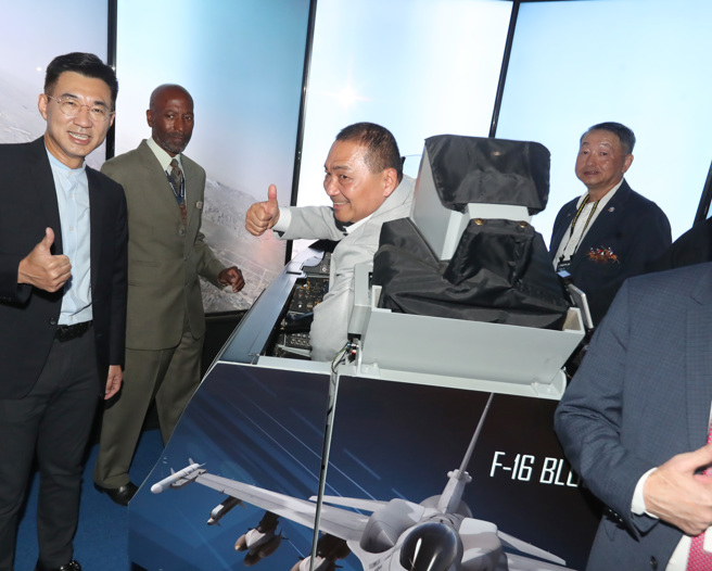 國民黨總統參選人侯友宜（中）14日參觀「2023台北國際航太暨國防工業展覽會」，特別參觀展場的美國館，並在F-16戰機製造商洛克希德馬丁公司的攤位使用F-16模擬器，體驗駕駛F-16的臨場感。 （鄭任南攝）