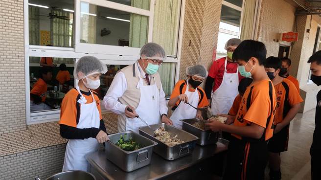 台南市長黃偉哲(左二)為學童裝盛營養午餐。（台南市政府提供／曹婷婷台南傳真）