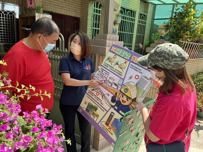 义消总队第三大队金寧防宣分队长周艺南(中)，10年来走访各家户宣导，深入社区建立防火防灾观念的努力备受肯定。(图／金门县消防局提供)