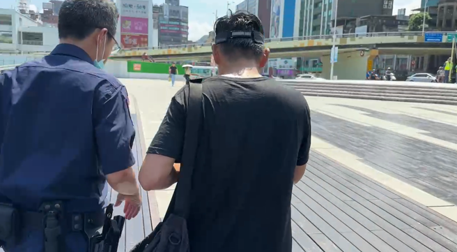 季克蛟上岸后与员警同行离去，照片上仍可见其浑身湿漉。（照片 / 民眾提供）