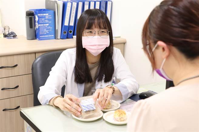 大里仁爱医院营养治疗科营养师沈沛仪（左）提醒，民眾享用月饼前可先翻看背面的「营养标示」了解含有多少热量、脂肪及糖量，并建议吃月饼1天不超过1个，热量控制在300大卡以内。（大里仁爱医院提供／潘虹恩台中传真）