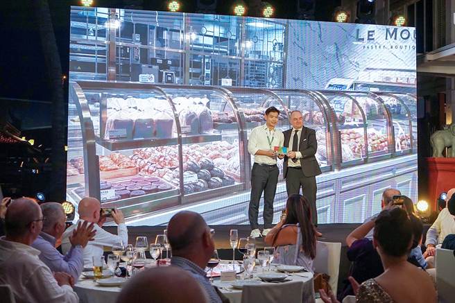 升恒昌免税商店于桃机第二航厦C区打造的「街口食趣」，于《2023机场餐饮论坛》击败欧美等眾多机场，夺下竞争最激烈的「最佳在地文化代表的机场餐饮」奖项，升恒昌免税商店总经理江建廷（左）亲自到泰国代表出席领奖。（升恒昌提供）