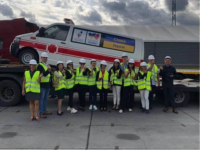 我国驻波兰大使吴尚年与乌克兰马尔哈涅茨市副市长杜普利等人在捐赠救护车前合影。（外交部提供)