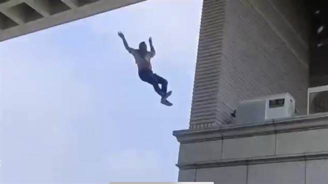 原本紧抓工地支撑物的工人因体力不支自高处坠落瞬间。民眾提供