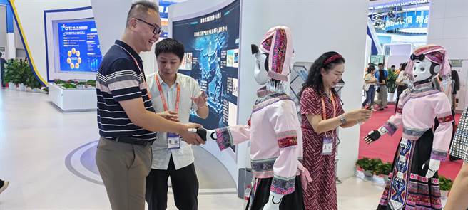 在「魅力之城」中国—东协资讯港展区，3个身穿壮族服饰、打扮成「刘三姐」造型的机器人正在展馆内「载歌载舞」。（主办方提供）