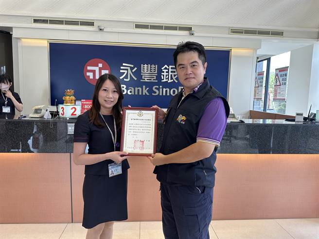 永丰银行金门分行行员机警成功协助阻诈，金城分局长方子钦(右)今日特别前往该分行表扬。(图／警方提供)