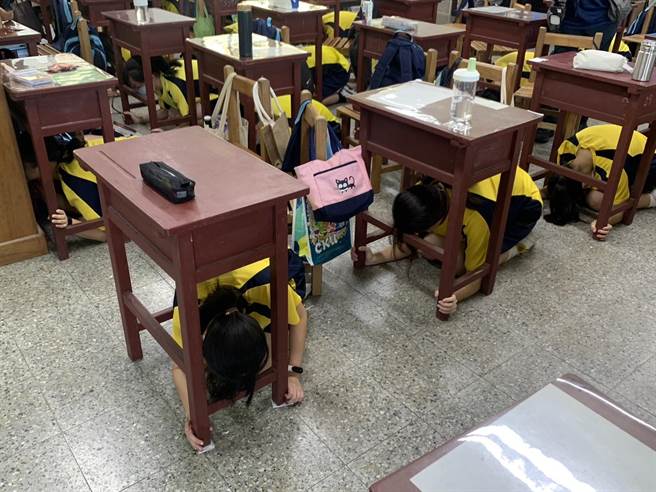 ▲武崙国中同学听到防灾警报通知后，迅速躲至书桌下执行「趴下、掩护、稳住」的动作，相当熟练。（徐佑升摄）